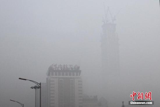 12月20日，北京CBD高樓在霧霾籠罩下若隱若現(xiàn)。中新社記者 富田 攝