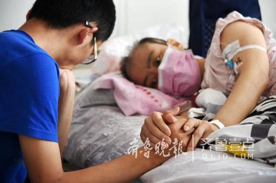 躺在病床上的母親緊緊地牽著兒子的手臂，眼神里有太多的牽掛和不舍。