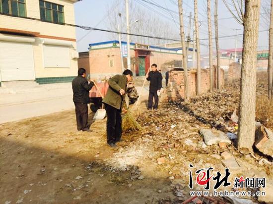 冬天和村民一起清理街道垃圾，右一為梁棟軍