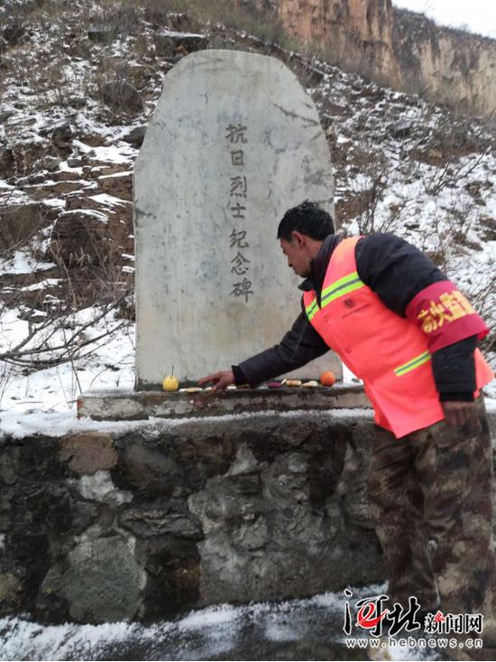 劉海清在烈士墓前擺放貢品。張長(zhǎng)江攝